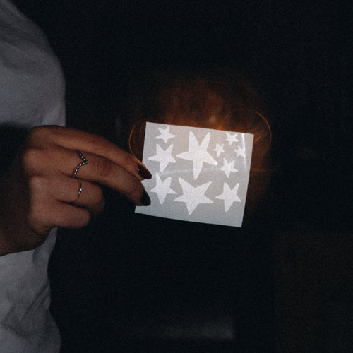 Auf dem Foto sieht man einen Stickerbogen mit verschiedenen Sternen. Die Sticker bestehen aus einer reflektierbaren Folie.