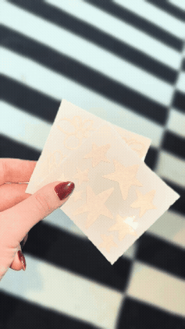 Auf dem Foto sieht man einen Stickerbogen. Der Stickerbogen besteht aus reflektierbarer Folie. Auf dem Bogen sind einmal verschiedene Sterne und auf dem anderen Bogen sind Blumen zu sehen.